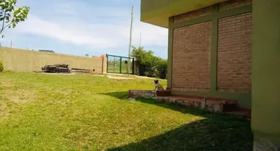a person sitting on a bench next to a building at Alquilo casa totalmente equipada con pileta y vista a las Sierras in Tanti