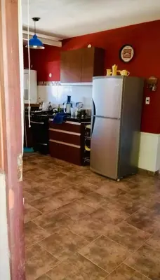 a kitchen with a stainless steel refrigerator and red walls at Alquilo casa totalmente equipada con pileta y vista a las Sierras in Tanti