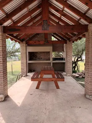 a picnic table under a pavilion with a picnic bench at Cabañas Gael in Barrio Parque El Corcovado