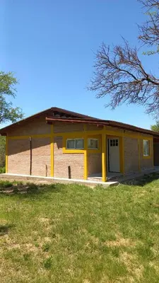 a house with a yellow in a field at Cabañas Gael in Barrio Parque El Corcovado