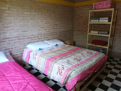 a bedroom with a bed and a brick wall at Cabañas Gael in Barrio Parque El Corcovado