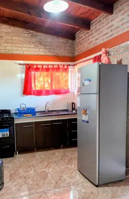 a kitchen with a stainless steel refrigerator and a window at Cabañas Gael in Barrio Parque El Corcovado