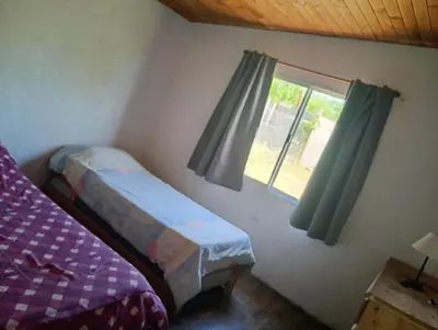 a bedroom with a bed and a window at Casita feliz in Villa del Dique