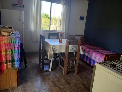 a room with a table and a bed and a window at Casita feliz in Villa del Dique
