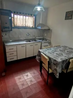 a kitchen with a table and a sink and a stove at El Paraiso 1 in Villa Carlos Paz