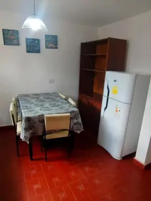a kitchen with a table and a white refrigerator at El Paraiso 1 in Villa Carlos Paz