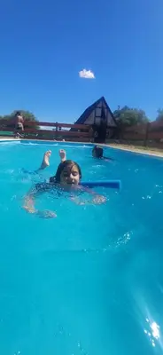 a woman is swimming in a swimming pool at las huertitas de milele in La Porteña