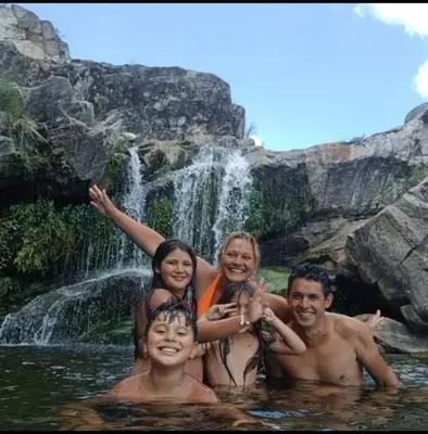 a group of people in the water in front of a waterfall at las huertitas de milele in La Porteña
