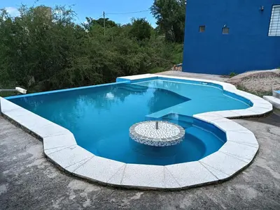 a swimming pool with a coping around it at Los Talitas in Villa Parque Siquiman