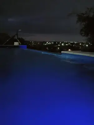 a swimming pool at night with the city lights at Los Talitas in Villa Parque Siquiman