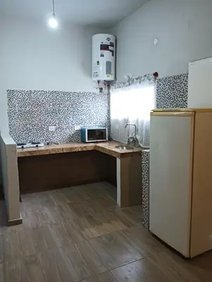 a kitchen with a counter with a microwave and a refrigerator at Los Talitas in Villa Parque Siquiman