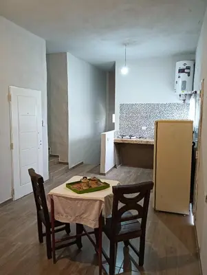 a kitchen with a table and two chairs and a refrigerator at Los Talitas in Villa Parque Siquiman