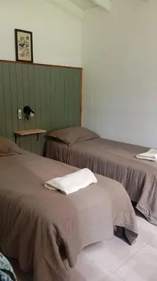 a room with two beds and a table with a lamp at Casita Salvia in Arroyo de Los Patos