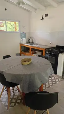 a kitchen with a table with chairs and a stove at Casita Salvia in Arroyo de Los Patos