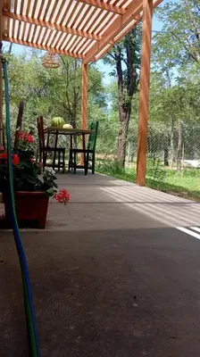 a wooden pergola with a table and a bench at Casita Salvia in Arroyo de Los Patos