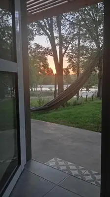 a porch with a hammock and a view of the sunset at Casita Salvia in Arroyo de Los Patos