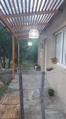 a patio with a wooden pergola and a house at Casita Salvia in Arroyo de Los Patos