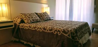 a bedroom with a bed with a comforter and pillows at edificio acuario 1 in Villa Carlos Paz