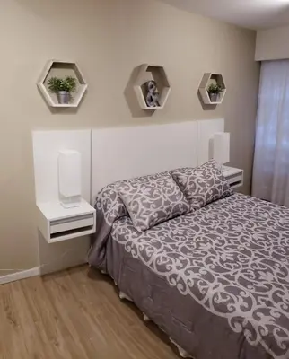 a bedroom with a bed and two lights on the wall at edificio acuario 1 in Villa Carlos Paz