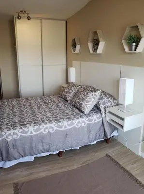 a bedroom with a bed and a nightstand and a bed sidx sidx sidx sidx at edificio acuario 1 in Villa Carlos Paz