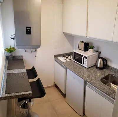 a small kitchen with a sink and a microwave at edificio acuario 1 in Villa Carlos Paz