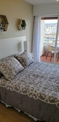 a bedroom with a large bed with a large window at edificio acuario 1 in Villa Carlos Paz