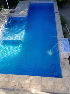 a swimming pool with blue water in a yard at Casa Del Mirador in Bialet Massé