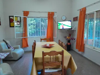 a living room with a table and a tv at Casa Del Mirador in Bialet Massé