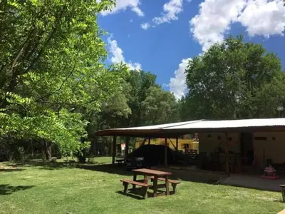 a picnic table in the grass next to a building at El descanso in Panaholma
