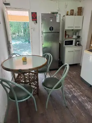 a kitchen with a table and chairs and a refrigerator at El descanso in Panaholma