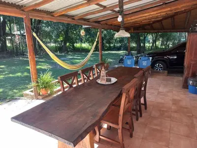 a wooden table and chairs on a patio with a hammock at El descanso in Panaholma