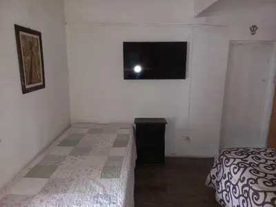 a bedroom with a bed and a television on the wall at El descanso in Panaholma