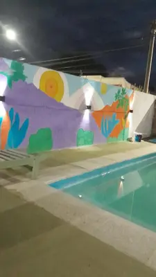 a swimming pool with a painting on a wall at JM brochero in Villa Cura Brochero