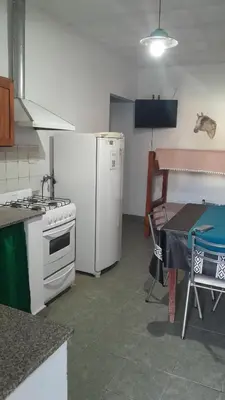a kitchen with a stove and a refrigerator and a table at JM brochero in Villa Cura Brochero