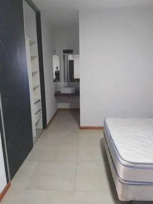 a bedroom with a bed and a kitchen in the background at Casa y cabañas Sara in Villa Rumipal