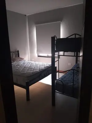 a bedroom with two bunk beds in a dark room at Casa y cabañas Sara in Villa Rumipal