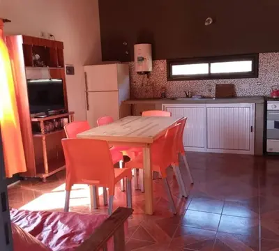 a kitchen with a wooden table and chairs at Casa y cabañas Sara in Villa Rumipal
