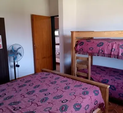 a bedroom with two bunk beds and a fan at Casa y cabañas Sara in Villa Rumipal