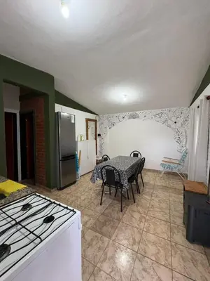 a kitchen with a table and chairs and a refrigerator at Las tres lunas 2 in Villa Anizacate