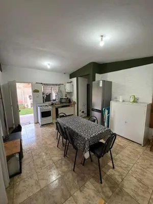 a kitchen with a table and some chairs and a refrigerator at Las tres lunas 2 in Villa Anizacate