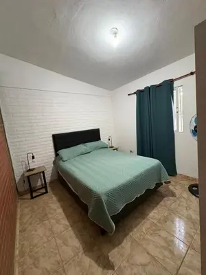a bedroom with a bed and a blue curtain at Las tres lunas 2 in Villa Anizacate