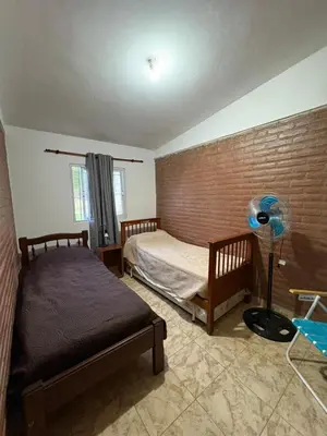 a bedroom with two beds and a brick wall at Las tres lunas 2 in Villa Anizacate