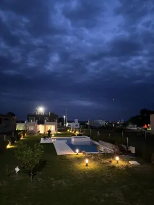 a backyard with a swimming pool at night at En Gracia, tu casa de Montaña in Alta Gracia