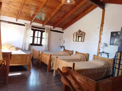 a room with beds and a table and chairs at Claro de Luna in Los Reartes
