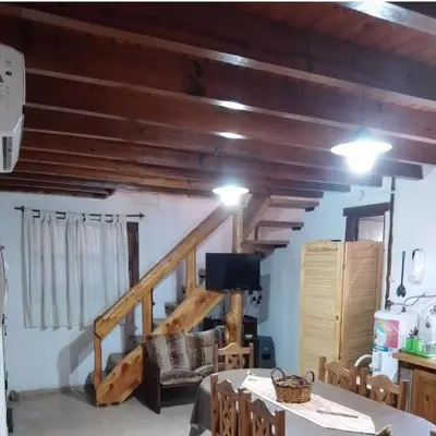 a living room with wooden ceilings and a staircase at Claro de Luna in Los Reartes