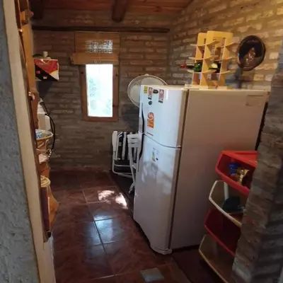a kitchen with a white refrigerator and a brick wall at Claro de Luna in Los Reartes