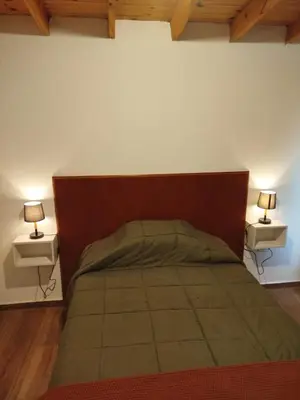 a bedroom with a bed with two lamps on two tables at Casa a estrenar En Trapiche - Pileta privada in Trapiche
