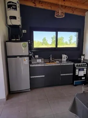 a kitchen with a refrigerator and a stove and a window at Casa a estrenar En Trapiche - Pileta privada in Trapiche