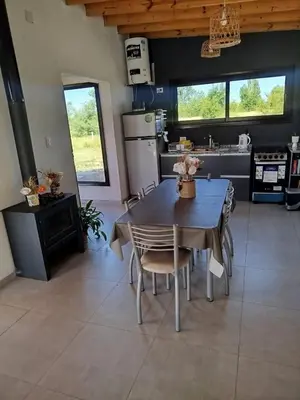 a kitchen with a table and chairs in a kitchen at Casa a estrenar En Trapiche - Pileta privada in Trapiche