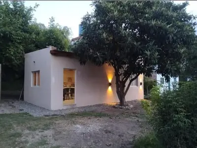 a small white house with a tree in front of it at Cabaña EL AROMO in La Paz
